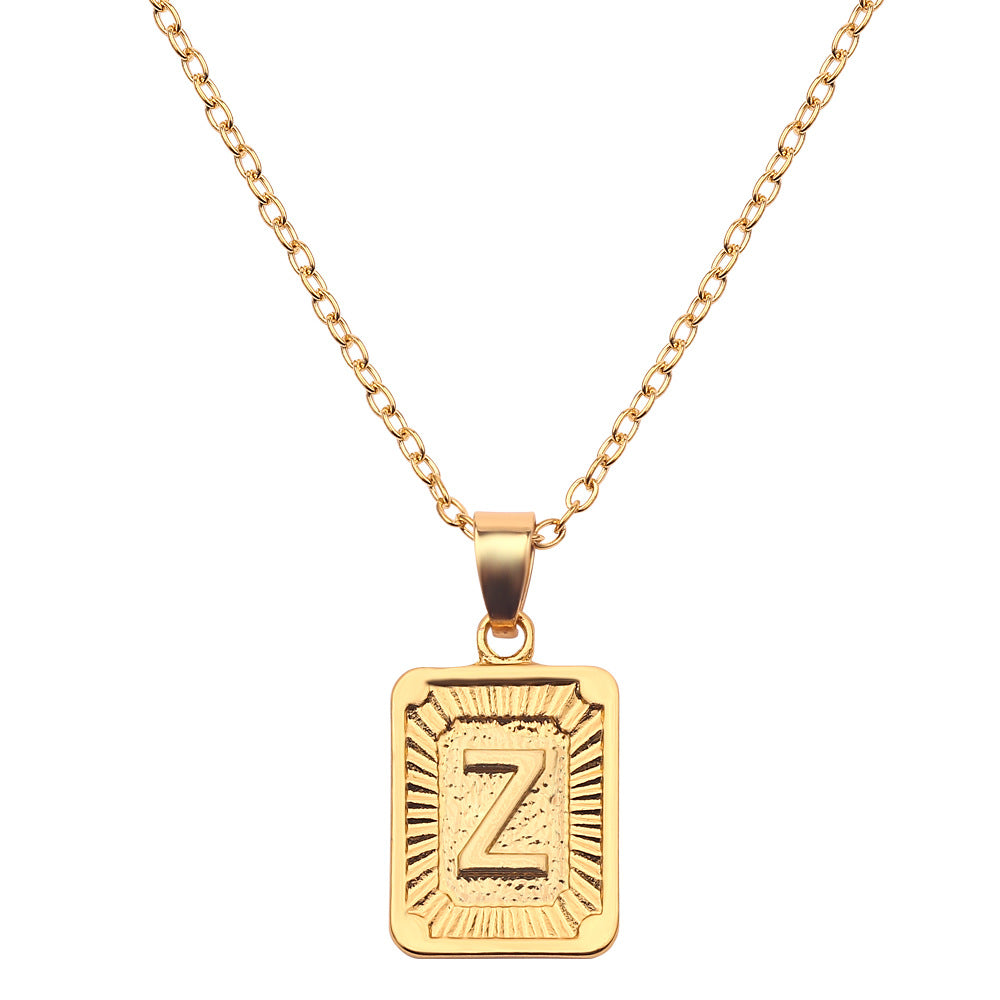 Gold necklace with a rectangular pendant featuring the letter 'Z' on a white background