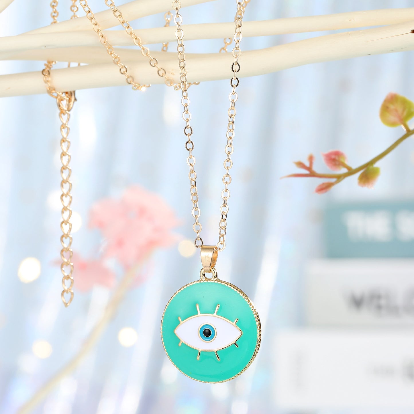 Necklace with a green eye pendant on a blurred background