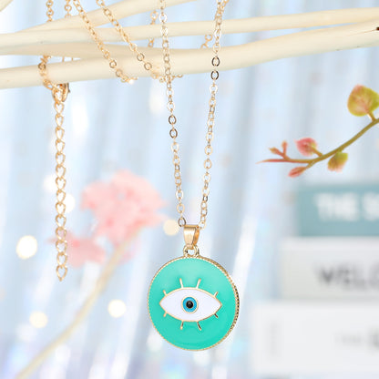 Necklace with a green eye pendant on a blurred background