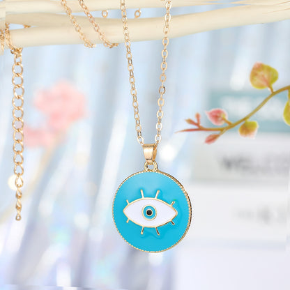 Necklace with a blue eye pendant on a blurred natural background