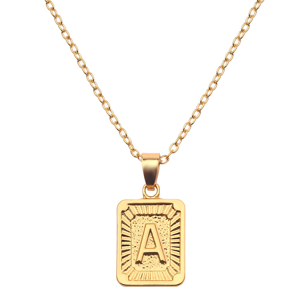 Gold necklace with a rectangular pendant featuring the letter 'A' on a white background