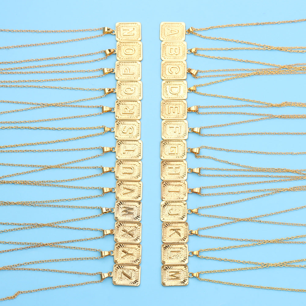 Gold chain necklaces with letter pendants on a blue background