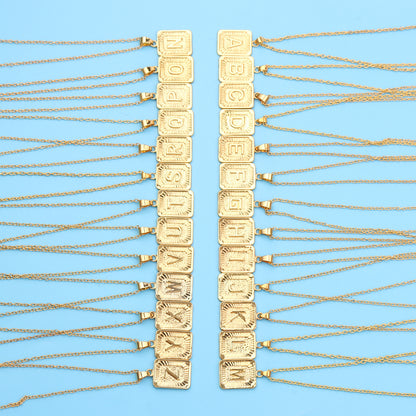 Gold chain necklaces with letter pendants on a blue background