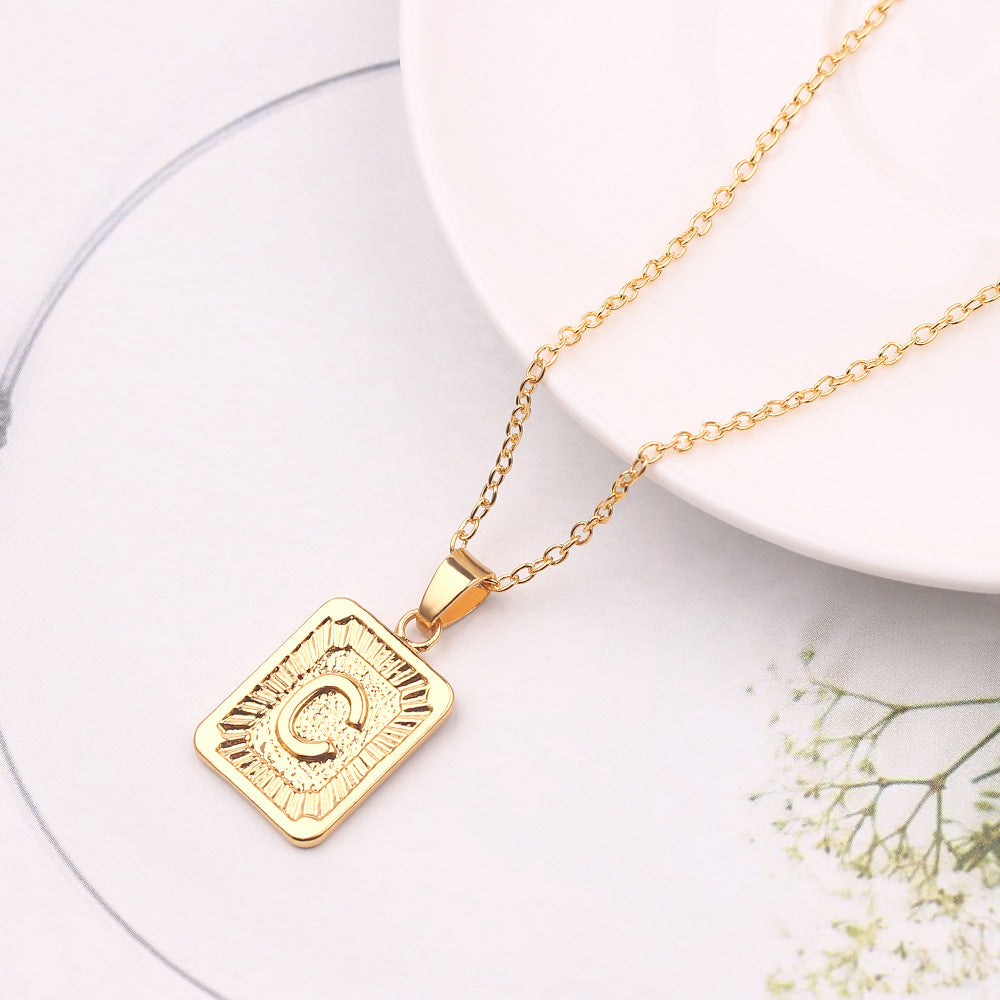 Gold necklace with a square pendant on a white background